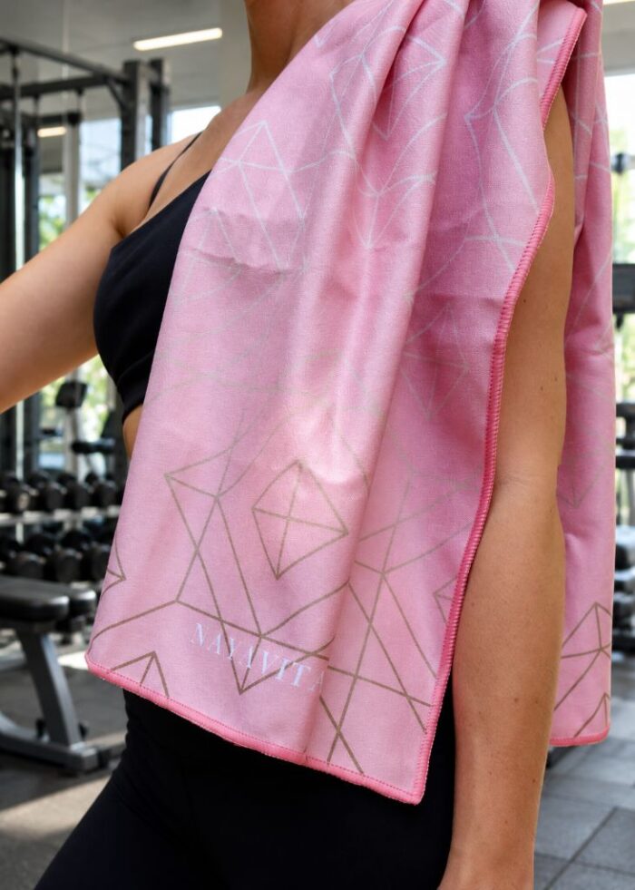 Woman in a gym with a microfibre sports towel over her shoulder