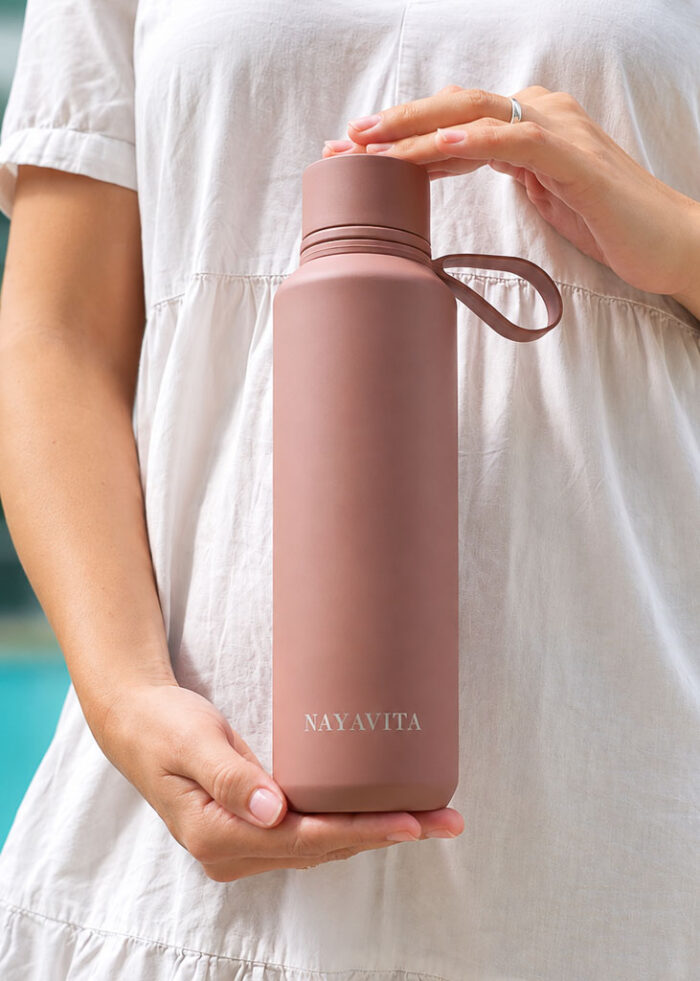 NAYAVITA detail lahve na pití v barvě Terracotta od NAYAVITA, žena láhev na vodu drží v ruce před kamerou